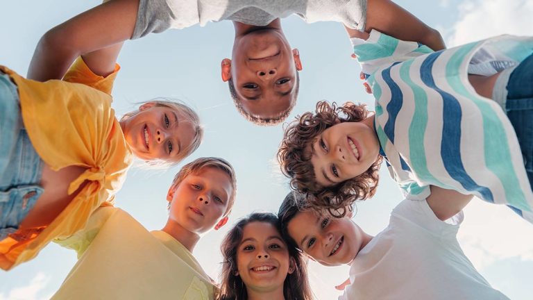 bottom view of positive multicultural children looking at camera , kids